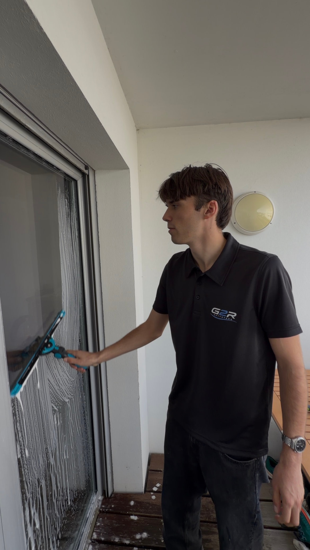 Laveur de vitres G2R Nettoyage nettoyant une baie vitrée à Rennes