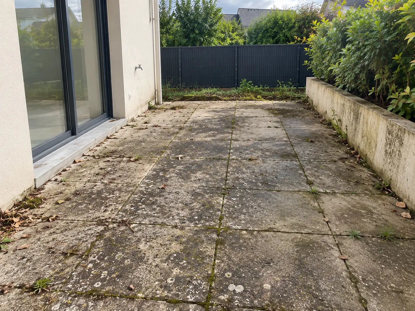 Terrasse dallée avec dépôts verts et salissures avant nettoyage par G2R Nettoyage à Rennes et alentours